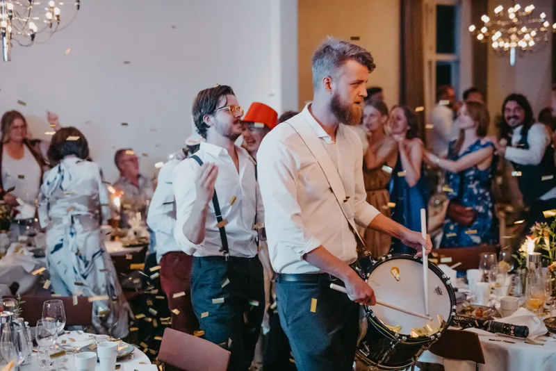 Fest med guldkonfetti och trummor bland gäster vid bord