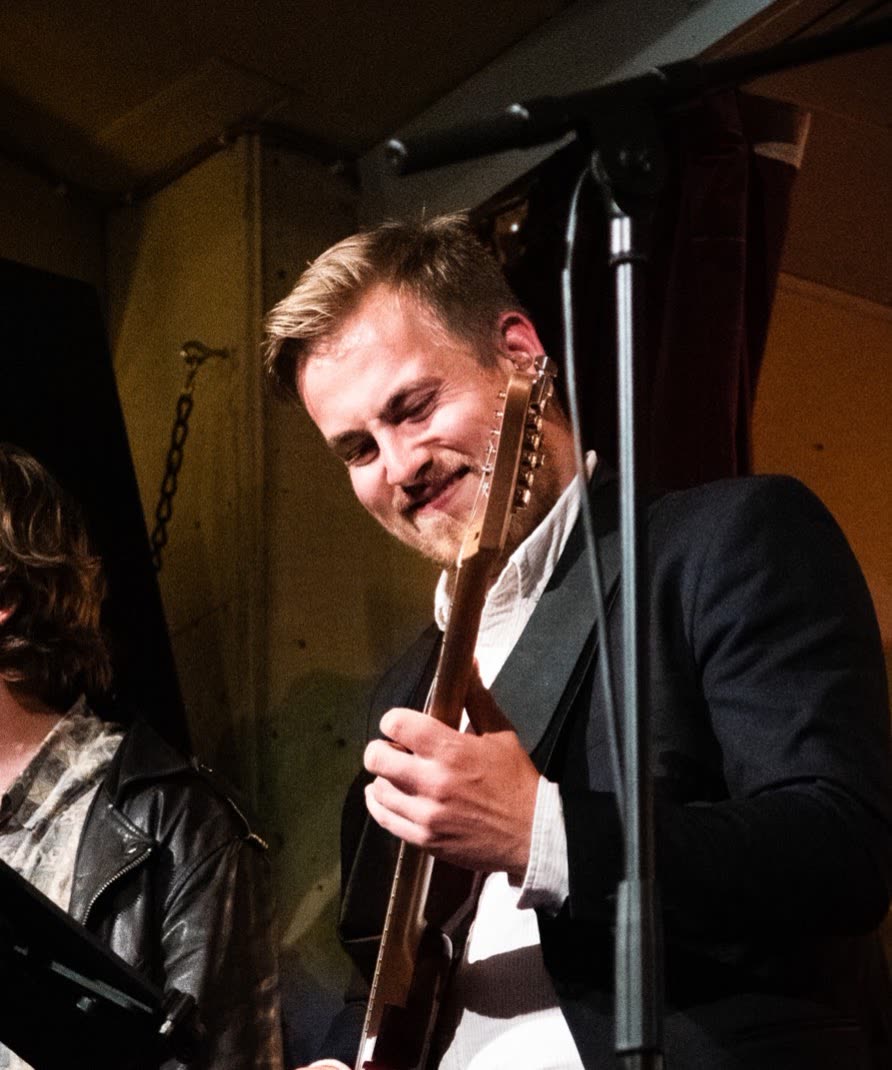 Edvin Sydmark, gitarrist och musiklärare med tajta funkkomp och hjältesolon med dist. ser du honom lägga ifrån sig gitarren och le: spring. en lek är på väg.
